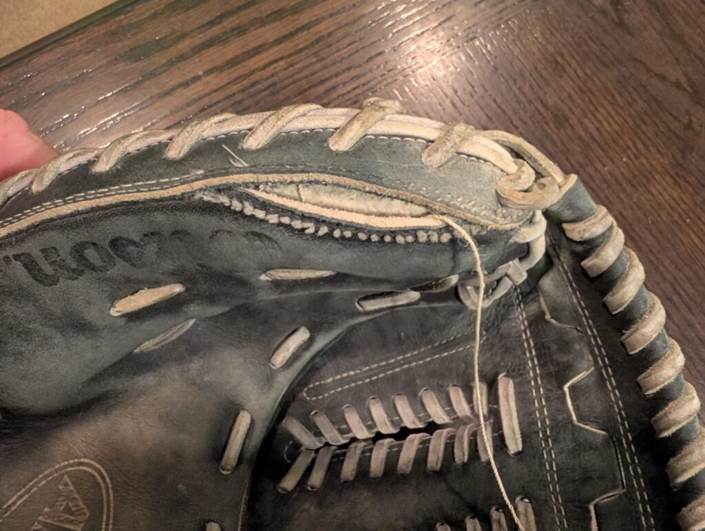 Torn baseball glove leather damage before repair
